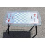 A mid century glass games table on wooden legs.. Size approx 75.5cm x 45.5cm, height approx 40cm.