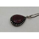 A white metal, ruby and diamond pendant, set large mixed pear shape cut ruby (length 20mm x width
