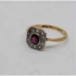 An Art Deco 18ct. gold, platinum, ruby and diamond ring, having central mixed cushion cut ruby in