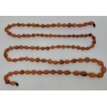 A string of graduated carnelian agate beads, strung as a necklace, length 139cm.