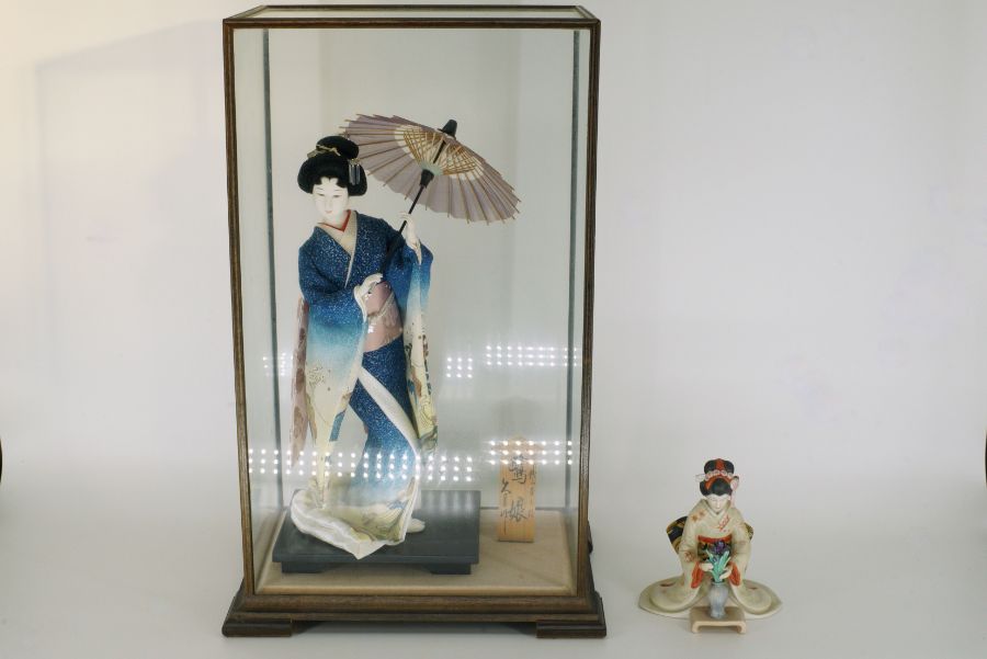 A cased model of a Geisha girl, height 22" and a porcelain model of a Geisha girl by Tamai, height