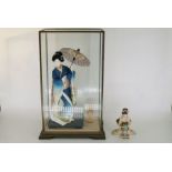 A cased model of a Geisha girl, height 22" and a porcelain model of a Geisha girl by Tamai, height
