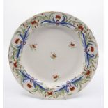 A Derbyshire fluted dinner plate, decorated with foliage tied together with a puce ribbon, the