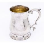 A George II plain silver baluster mug / tankard, with S-scroll handle, raised foot, gilt interior,