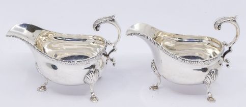 A pair of Georgian style large oval sauceboats, gardroon border on three shell and hoof feet, S-