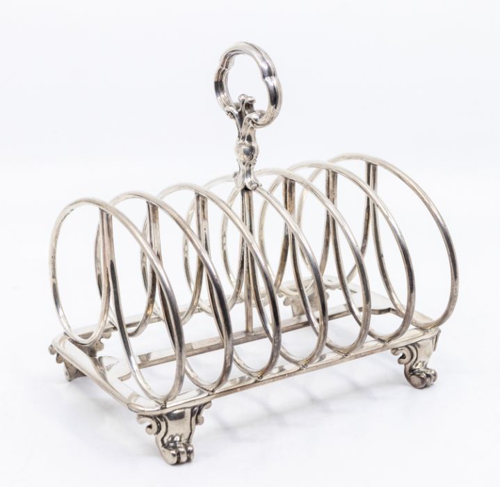 An early Victorian large silver seven bar toast rack, on rectangular base with four scroll feet,