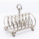 An early Victorian large silver seven bar toast rack, on rectangular base with four scroll feet,