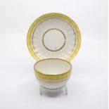 A Derby puce mark tea bowl and saucer, c.1790, decorated in pattern no.411, with a yellow ground rim