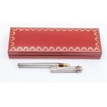 A Cartier Must de Cartier Trinity Vendome fountain pen in a silver metal with gilt banding on lid.