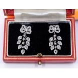 A pair of ornate diamond and 9ct white gold drop earrings, comprising a bow top grain set with small