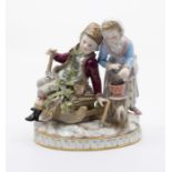 A 19th century Meissen porcelain figure of Winter, with a young boy sitting on a sled with