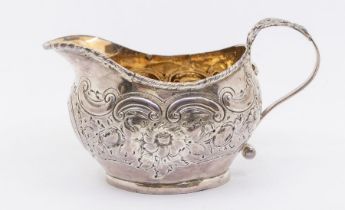 A George III silver cream jug, later profusely chased with flowers, gadroon rim, by CB?, London,