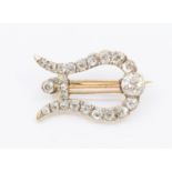 An early 20th century diamond brooch in the form of a lyre, set with old cut diamonds, with gold