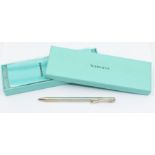 A Tiffany & Co silver retractable purse ballpoint pen, designed by Elsa Peretti, along with