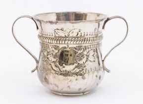 A George III silver two handled loving cup, waisted with flared rim, the body chased with flowers,