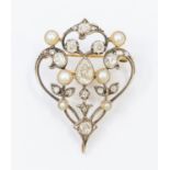 A Belle Epoque diamond and pearl set gold brooch comprising a open wire scrolled form decorated with