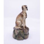 An S & H Derby King St Factory model of a Saluki hound, sitting on a rocky mound, S & H Derby blue