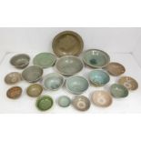 A group of eighteen Chinese and South East Asian celadon bowls, of various ages, incised with