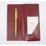Cartier Must de Cartier gold-plated ballpoint pen, knurled body, trinity decoration, clip with red