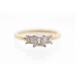 A three stone diamond and 18ct gold ring, comprising a central claw set princess cut diamond