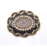 An early 19th Century oval enamel, seed pearl and yellow metal mourning brooch, comprising a central