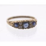 A sapphire and diamond 9ct gold ring, comprising three round cut sapphires, intersected with