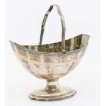 A George III silver bright cut engraved boat shaped sugar basket, with shaped reeded swing handle,