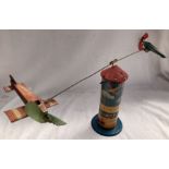 Tinplate: A vintage tinplate clockwork aeroplane tower, made in Germany. Fixed handle to wind