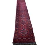 A handmade, hand knotted, Indian hall runner in a deep red, indigo and burnt orange wool 2 1/2 by