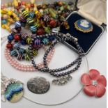 A selection of costume jewellery to include two strands of dyed freshwater pearls, a paste brooch, a