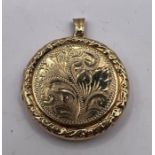 ***AWAY REF CH 27/07***An engraved circular locket in 9ct gold. Engraved with a foliate pattern.