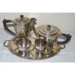 A silver five piece tea and coffee service with cast band, engraved monogram and stepped circular