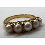 A 19th century half hoop pearl set ring. Testing as 18 carat gold with five whole pearls claw set