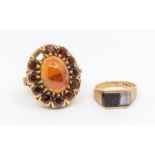 A garnet and 9ct gold cluster ring set to the centre with an oval cabochon garnet within a border of