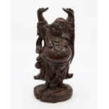 A carved cherrywood figure depicting the laughing Buddha, with hands aloft, wearing pearls of