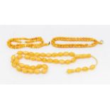 A Collection of two egg yolk amber bead necklaces and a composite amber bead necklace