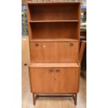 A 1970s teak drinks cabinet and display unit with dropdown serving door, having a mirror back