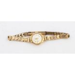 A vintage 9ct gold ladies Seiko wristwatch, round silvered dial,  on a 9ct gold strap, total gross