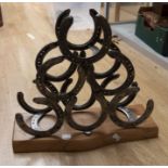 Collection of walking sticks in stick stand along with horse shoe wine/bottle rack