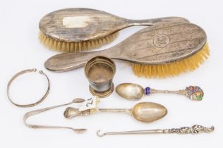 A collection of silver items to include: silver mounted hair brushes, button hook, two spoons, egg
