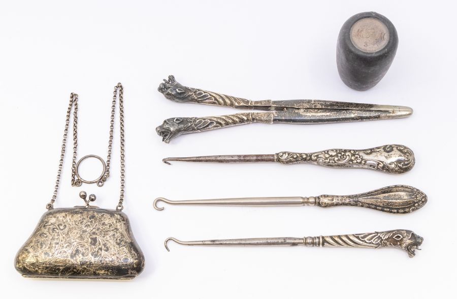 A collection of silver to include: monogrammed purse, three button hooks and glove stretcher, and