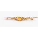 A 9ct gold and yellow paste set bar brooch, foliate decoration set to the with an oval paste, to a