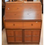A 1970s teak bureau with pull-down desk top above two drawers and two lower cupboard doors