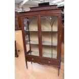 An Edwardian mahogany two shelf display cabinet on tapered legs, having glazed doors and sides