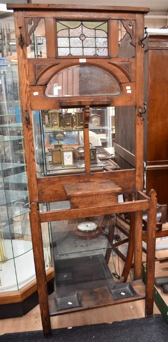 An Edwardian hall stand with stained glass panel, hat and coat hooks and umbrella stand