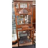 An Edwardian hall stand with stained glass panel, hat and coat hooks and umbrella stand