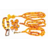 A collection of amber bead necklaces, to include three clarified versions with round beads, one with