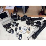 A large collection of camera equipment including studio camera, tripods, vintage phones, early