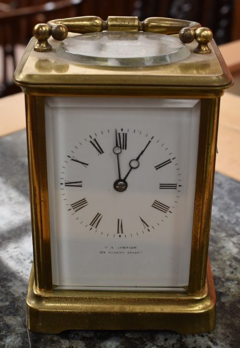 An early 20th Century giltmetal carriage clock, white enamel dial with Roman numerals, retailed by T