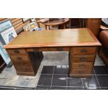 A mid 20th Century pedestal desk and the upper section of a bureau bookcase converted into a floor-